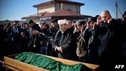 Members of the Crimean Tatar community pray over the coffin of Reshat Ametov during his funeral in Simferopol on March 18. His body bore the marks of a violent death, according to Human Rights Watch.