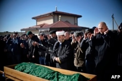 Members of the Crimean Tatar community pray over the coffin of Reshat Ametov during his funeral in Simferopol on March 18, 2014. He was found dead on the day of the referendum. His body bore signs of torture.