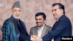 Iran - Iranian President Mahmud Ahmadinejad (C), his Afghan counterpart Hamid Karzai (L) and their Tajik counterpart Imomali Rakhmon join hands during a trilateral regional summit in Tehran, 05Aug2010