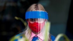 Сотрудница ресторана с пластиковым щитом на лице. Москва, 8 июля 2020 года.