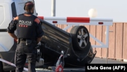 Поліцейський стоїть біля автомобіля, що був використаний у нападі в Камбрілсі, за 120 кілометрів від Барселони, 18 серпня 2017 року
