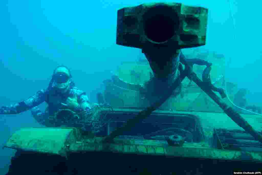 A diver poses for a photograph next to an immersed tank 3 kilometers off the coast of the southern Lebanese port city of Sidon, where environmental activists dropped old battle tanks provided by the Lebanese Army into the Mediterranean Sea to create new habitat for marine life. (AFP/Ibrahim Chalhoub)