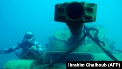A diver poses for a photograph next to an immersed tank 3 kilometers off the coast of the southern Lebanese port city of Sidon, where environmental activists dropped old battle tanks provided by the Lebanese Army into the Mediterranean Sea to create new habitat for marine life. (AFP/Ibrahim Chalhoub)