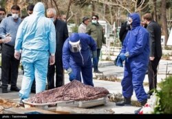 Похороны умершего от коронавируса человека в Иране.