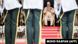 Король Малайзии Мохаммед V (на заднем плане)
