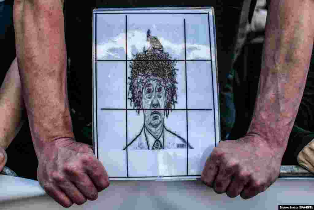 A protester holds a caricature of Czech Prime Minister Andrej Babis as thousands of demonstrators gathered on Wenceslas Square to protest against Babis and the new justice minister, Marie Benesova, in Prague. Babis is suspected of alleged misuse of some $2 million in EU subsidies. (epa-EFE/Bjoern Steinz)