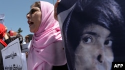 University students and independent civil society activists take part in a demonstration in support of passing the Elimination of Violence Against Women law in front of parliament in Kabul on May 27.