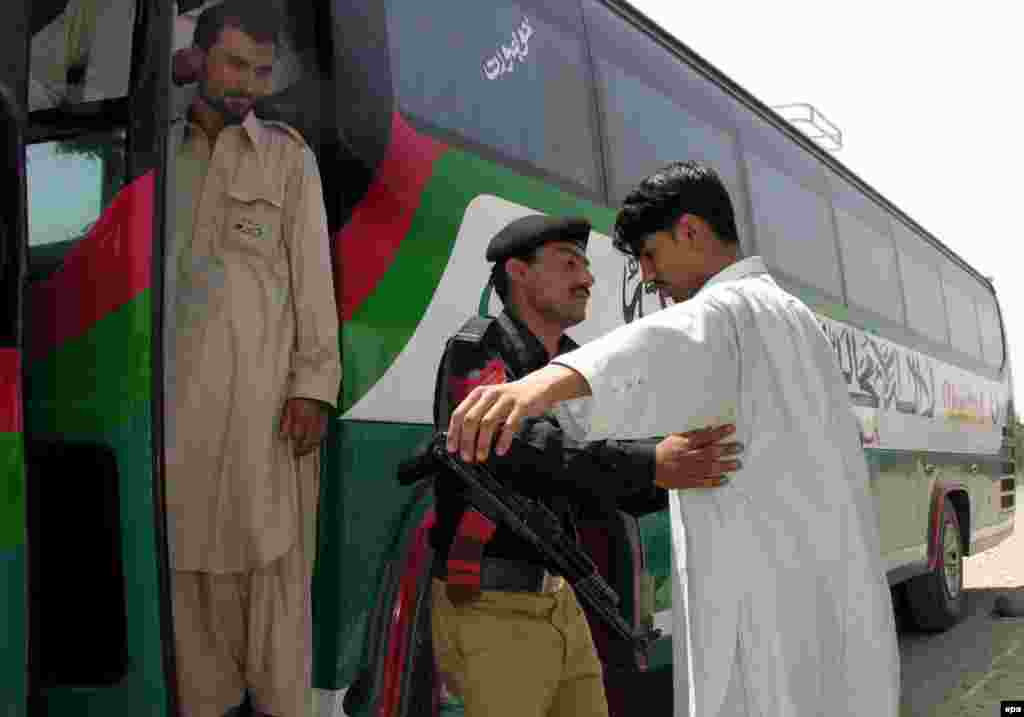 Pakistan -- A Pakistani Policeman inspects the passengers of the first regular Pak-Afghan Bus (Peshawar-Jalalabad Bus) as the bus leaves Peshawar for Jalalabad, 26 May 2006 - PAKISTAN AFGHANISTAN epa00722885 A Pakistani Policeman inspects the passengers of the first regular Pak-Afghan Bus (Peshawar-Jalalabad Bus) as the bus leaves Peshawar for Jalalabad on Friday 26 May 2006. Pakistan and Afghanistan on Friday began the first ever bus service between their main border cities as the two capitals try to calm recent tension over the cross-border infiltration of Islamic militants. EPA