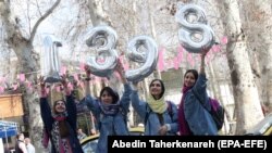 Iranian girls hold up numbers forming the Persian new year 1398 ahead of Norouz in Tehran on March 20.