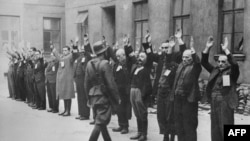 Нацисты осматривают группу еврейских мужчин. Варшава, апрель 1943 года.