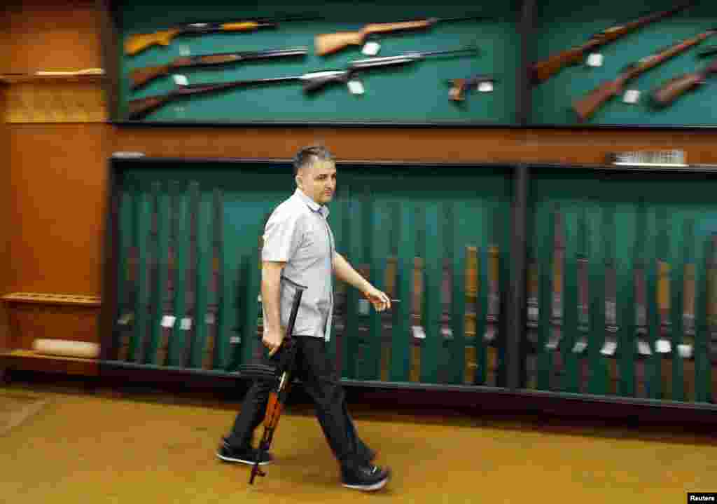 A worker carries an assault rifle in the factory&#39;s exhibition hall. The factory sells weapons to clients in Africa and the Middle East -- former partners during the Yugoslav era -- and even the United States, which led the NATO air war against Serbian forces in 1999.