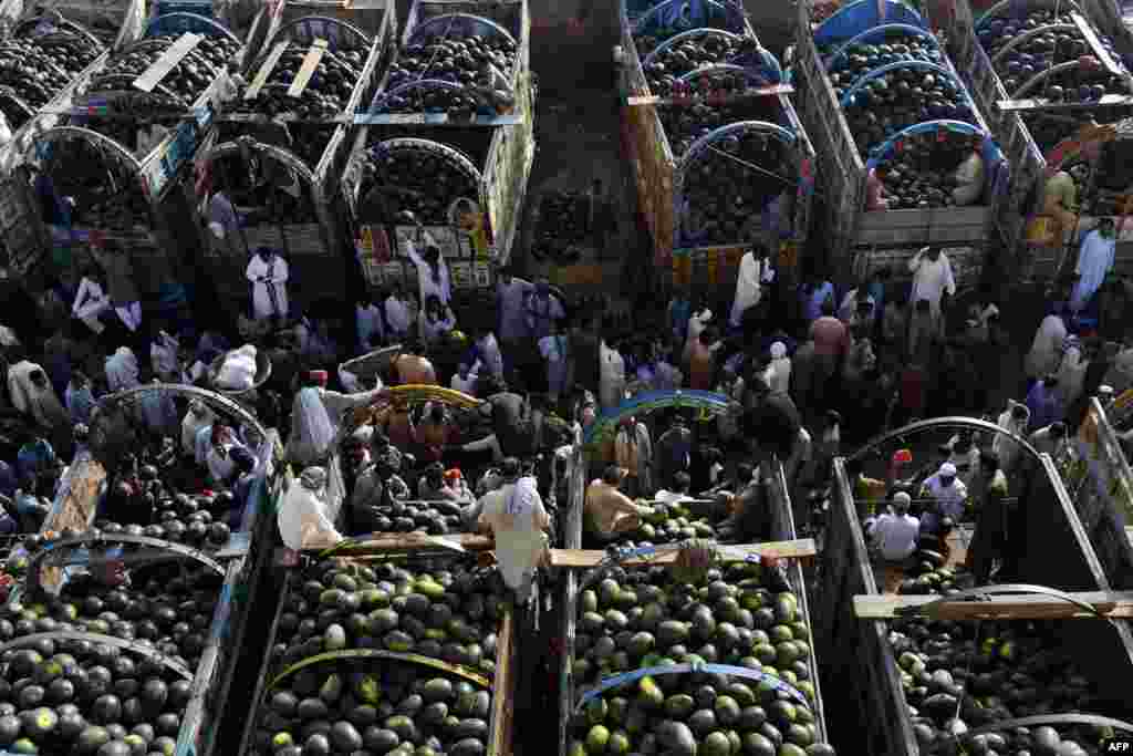 Pakistani farmers gather at a fruit market to sell watermelons in Lahore. (AFP/Arif Ali)