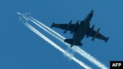 Ukraine -- A Su-25, refered to by NATO as "Frogfoot", flies below a passanger aircraft during military exercises dubbed Perspekyiva-2012 (Perspective-2012) near the city of Ghytomyr, 27Sep2012