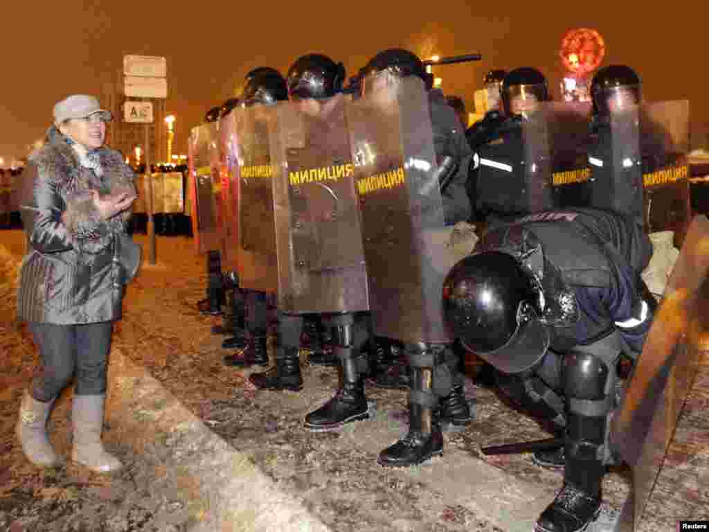 An opposition supporter appeals to riot police for sympathy.