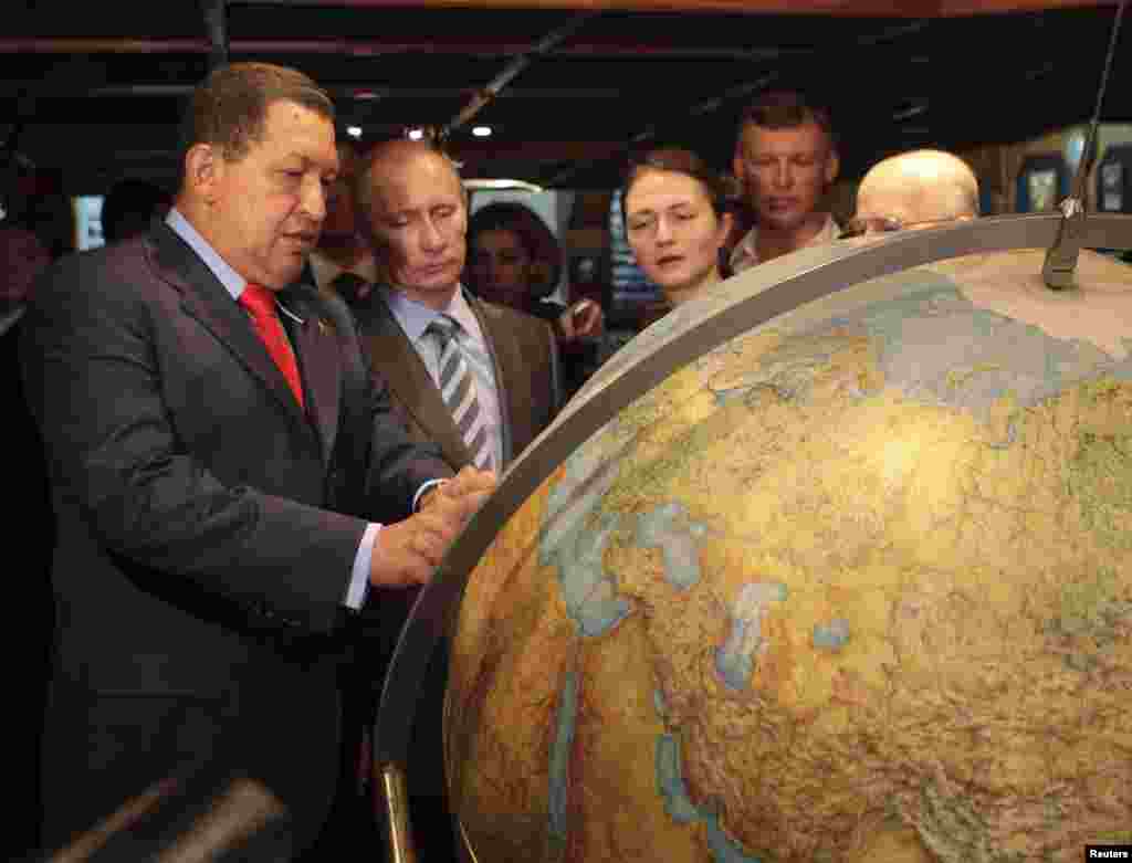 Чавес і тодішній російський прем’єр Володимир Путін дивляться на глобус під час візиту на російський парусник «Крузенштерн», пришвартований у порту біля Каракаса, у квітні 2010 року.