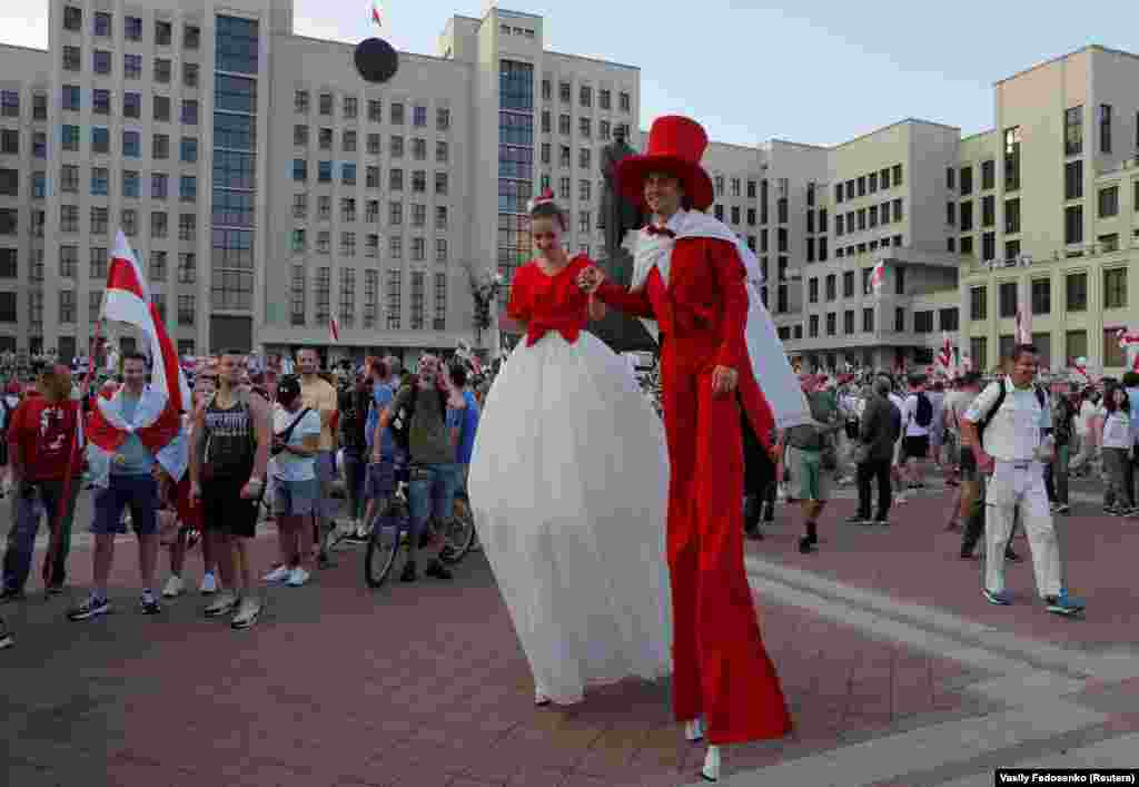 Performers on stilts and dressed in the colors of the historical white-red-white flag of Belarus take part in an anti-government protest in Minsk on August 16.