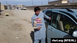 یو افغان ځوان عظمت کټوازی د ځوانانو ترمنځ د دودولو لپاره په خپل مالي لګښت د اخیستل شویو کتابونو د وېشلو پر مهال