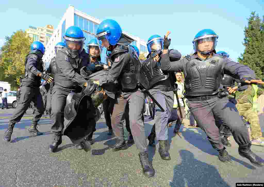 Полиция тащит Керемли в автозак. Власти перед акцией протеста закрыли несколько станций метро рядом с местом проведения несанкционированной акции 19 октября.