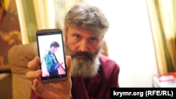 Архієпископ УПЦ КП Климент показує на телефоні зображення чоловіка у формі. Сімферополь, 31 серпня 2017 року