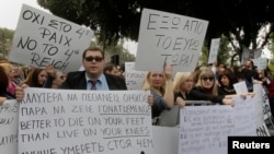 Protesters take part in an antibailout rally by employees of Cyprus Popular Bank outside the parliament in Nicosia on March 22.