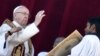 Pope Francis (L) blesses the faithful from the balcony of St Peter's basilica 