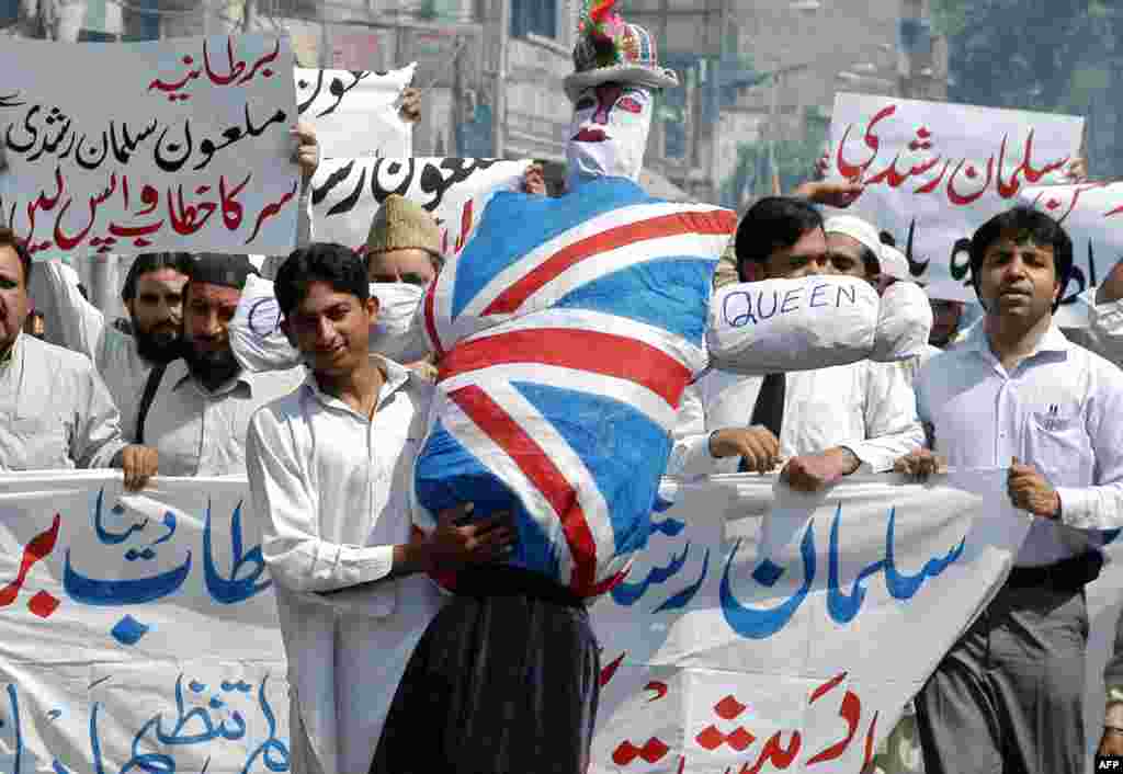 A man displays an effigy of Queen Elizabeth as he marches with others during an anti-British protest in Lahore, Pakistan in June 2007, shortly after the honor was announced for Rushdie.