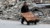 A man selling pastries walks past the rubble of damaged buildings in the rebel held al-Shaar neighborhood of Aleppo on February 10.