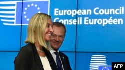 Donald Tusk, premierul polonez ales președinte al CE, și Federica Mogherini, șefa diplomației italiene, aleasă ca responsabilă a politicii externe a UE, sosind la conferința de presă de la Bruxelles, sîmbătă seară. 