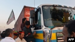 Pakistan -- Supporters of Imran Khan, head of Pakistan Tehreek-e-Insaf (PTI) party, check the documents of a truck driver at an unofficial checkpoint in a bid to block the NATO supply trucks in Peshawar, December 4, 2013