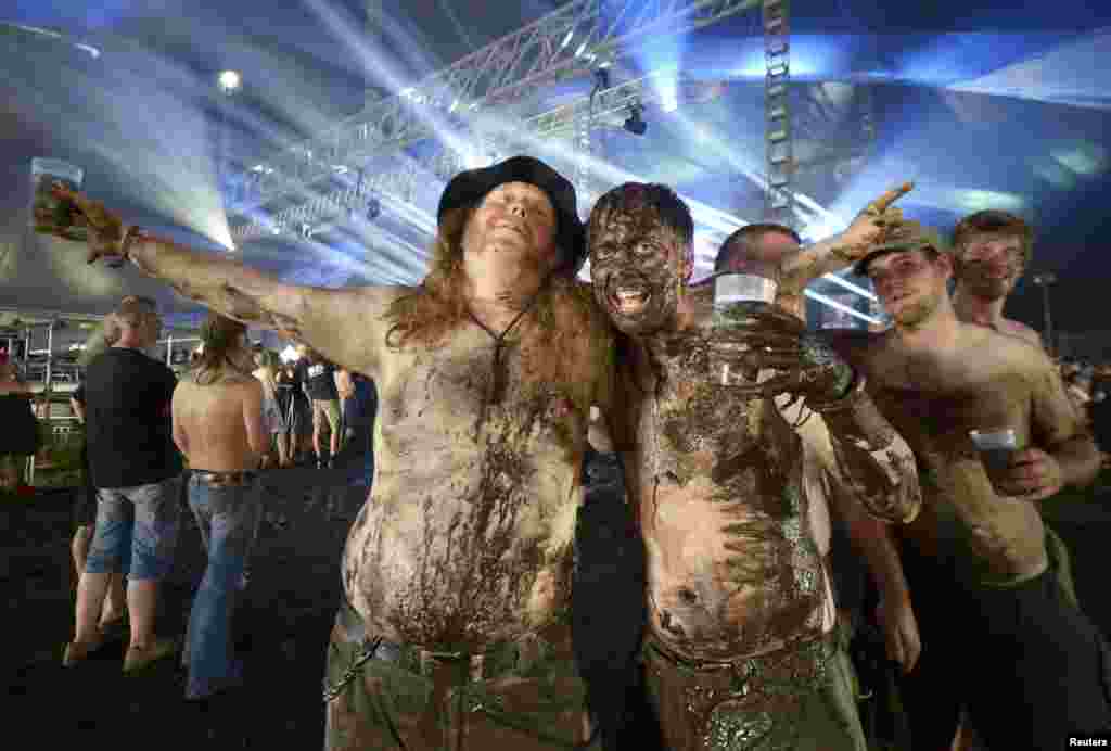 Heavy-metal fans covered with mud pose for photographers during the 24th Wacken Open Air Festival in Wacken, Germany. (Reuters/Fabian Bimmer)