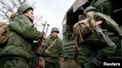 Войници от проруските сепаратистки части се качват в камион край село Петривске