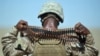 FILE: A U.S. Marine removes a bandolier of ammunition from around his neck during a group shooting lesson for Afghani police in Helmand.