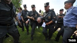 Russian police detain a gay-rights supporter during a protest rally in St. Petersburg in July. Critics fear the authorities will use the new law to jail any dissenters.