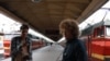 Blogger and activist Ilya Varlamov (right, with camera) working on his civil activism campaign on a Moscow train platform with a fellow activist.