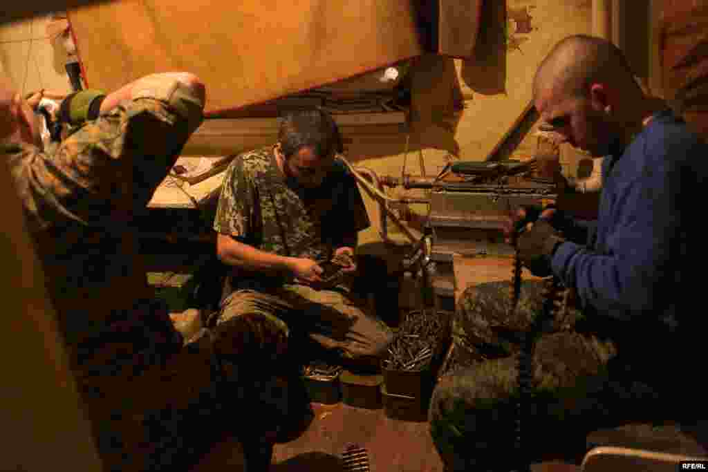 The volunteers prepare their weapons after intelligence reports indicate a heavy night of fighting lies ahead. On the left is Avram, an Orthodox Jew from western Ukraine. The Russian media has portrayed Ukraine&#39;s leaders as fascists, but he&nbsp;says he has never experienced anti-Semitism in his country.