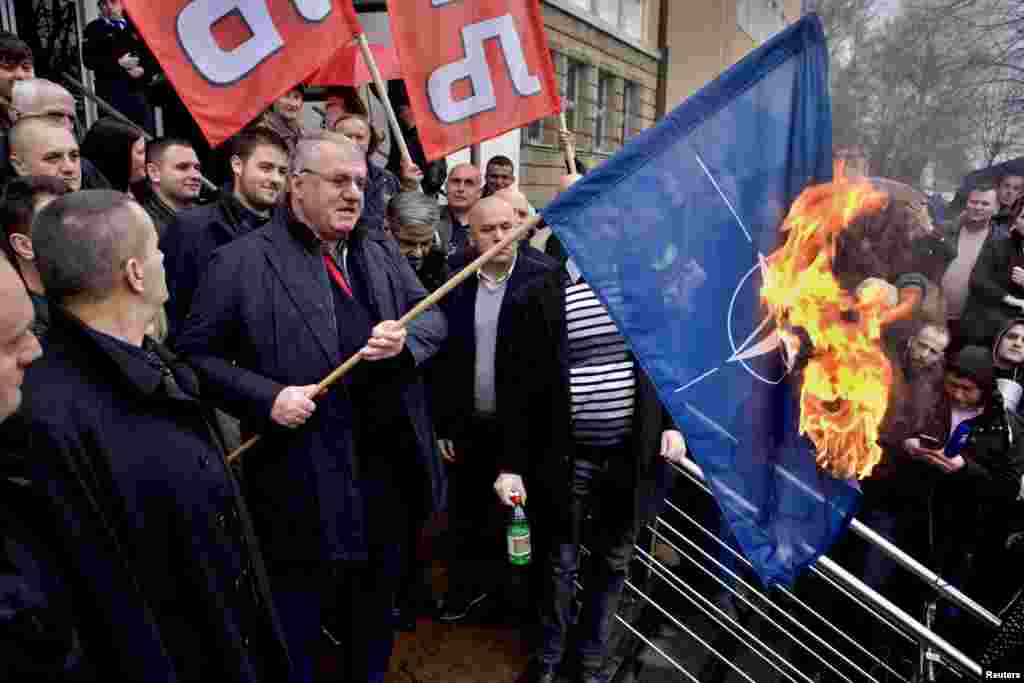 Serbia -- Serbian ultra-nationalist leader Vojislav Seselj, surrounded by his Radical Party supporters, burns a NATO flag during a protest in front of the Special Court building in Belgrade, March 10, 2016