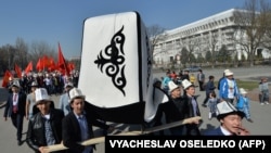 Kyrgyz people wear traditional hats and carry a big Kyrgyz cap (kalpak) and national flags during a rally marking Kyrgyz Cap Day" in Bishkek in March 2016.