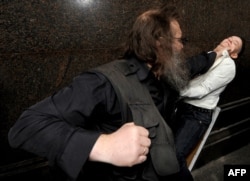 A Russian man attacks an LGBT rights activist during a rally in central Moscow in 2013, the same year that Russian President Vladimir Putin signed a controversial law against the "propaganda of nontraditional sexual relations" among minors.