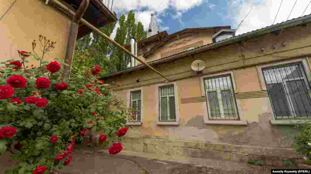 Во внутреннем дворе под домом Ракова пышно зацвел куст розы