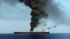 A TV grab reportedly shows smoke billowing from a tanker attacked off the coast of Oman, June 13, 2019