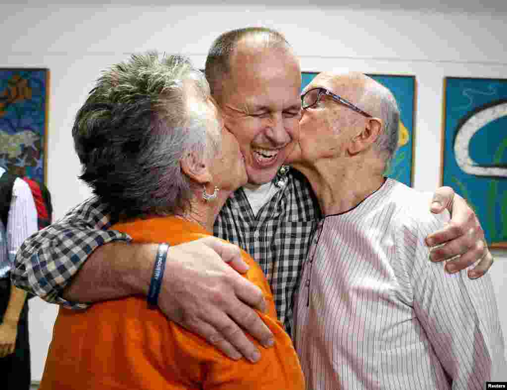 Australian journalist Peter Greste (center) receives a kiss from his mother, Lois, and father, Juris, upon his return home at Brisbane International Airport. Greste, the Al-Jazeera journalist freed after more than a year in an Egyptian prison, arrived back in his Australian homeland on February 5 and called for the release of two colleagues still in custody. (Reuters/Nathan Richter)