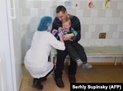 Киевская медсестра делает прививку ребенку