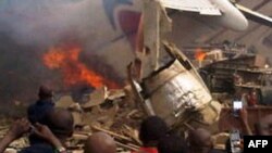 A picture taken with a camera shows residents of the Iju district of Lagos gathering at the site where a Dana Air plane crashed on June 3.