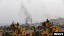 Forcat e Turqisë në kufirin me Sirinë, ndërsa në plan të dytë shihet qyteti Kobani 