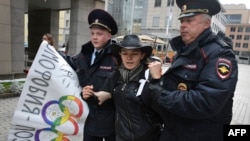 Moscow police detain a rights activist during a protest against a ban on staging a gay pride parade during the Sochi Olympics.