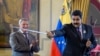 Venezuelan President Nicolas Maduro (right) holds a sword, given as gift by Russian oil company Rosneft CEO Igor Sechin, during the signing of agreements at the Miraflores presidential palace in Caracas on July 28. (AFP/Federico Parra)