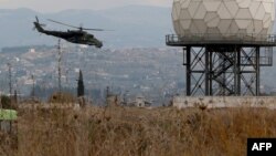 Syria -- A helicopter flies near a radar at the Russian Hmeimim military base in Latakia province, in the northwest of Syria, December 16, 2015