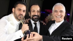 Иран режиссері Асгар Фархади (ортада) және оның "Бөліну" фильмінде бас кейіпкерді сомдаған актер Пейман Маади (сол жақта), фильмнің қоюшы-операторы Махмуд Калари "Оскар" жүлдесін алып тұр. 