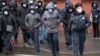 A Russian policeman accompanies a group of migrant laborers seeking to renew their work permits at a migration center in St. Petersburg earlier this month. 