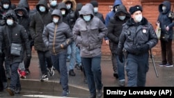 A Russian policeman accompanies a group of migrant laborers seeking to renew their work permits at a migration center in St. Petersburg earlier this month. 